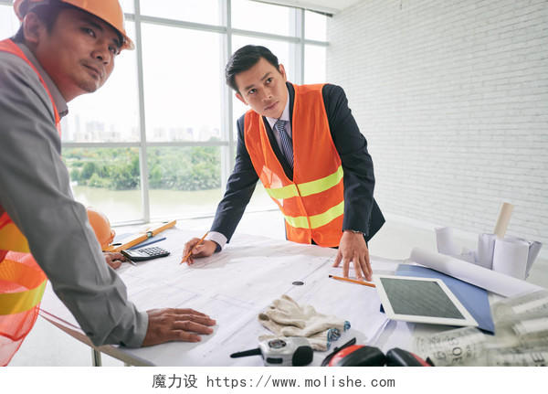 建筑工地施工现场建筑工人研究图纸工人讨论指导工作